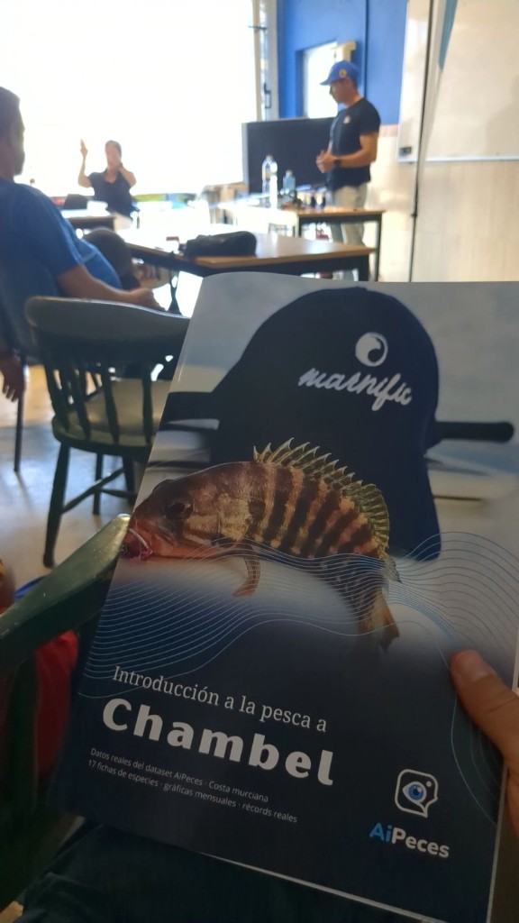 Participante mostrando la libreta de formación «Introducción a la pesca a Chambel» durante la jornada en Cartagena
